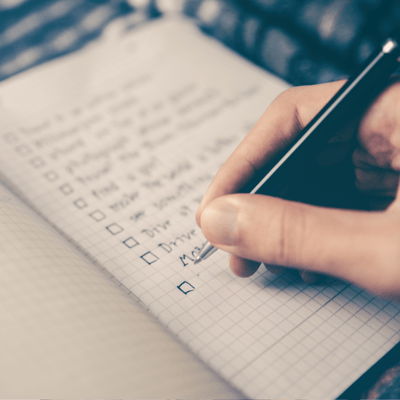 A person is writing his goals on a piece of paper. He is using right hand and black pen. There are a couple goals already written. A person is writing his goals on a piece of paper. He is using right hand and black pen. There are a couple goals already written.
