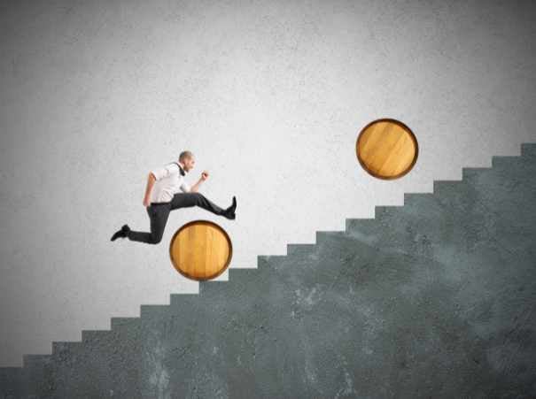 Businessman jumping obstacles on the staircase